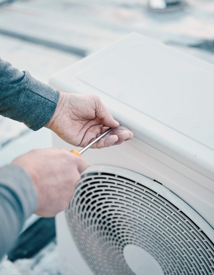 Hands, air conditioner and maintenance with a man construction worker on a rooftop to install a coo